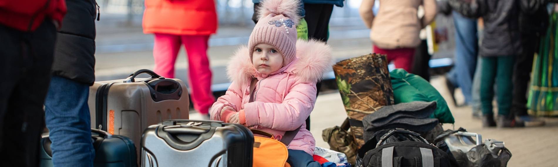 Flüchtlinge Ukraine Kind auf Koffern
